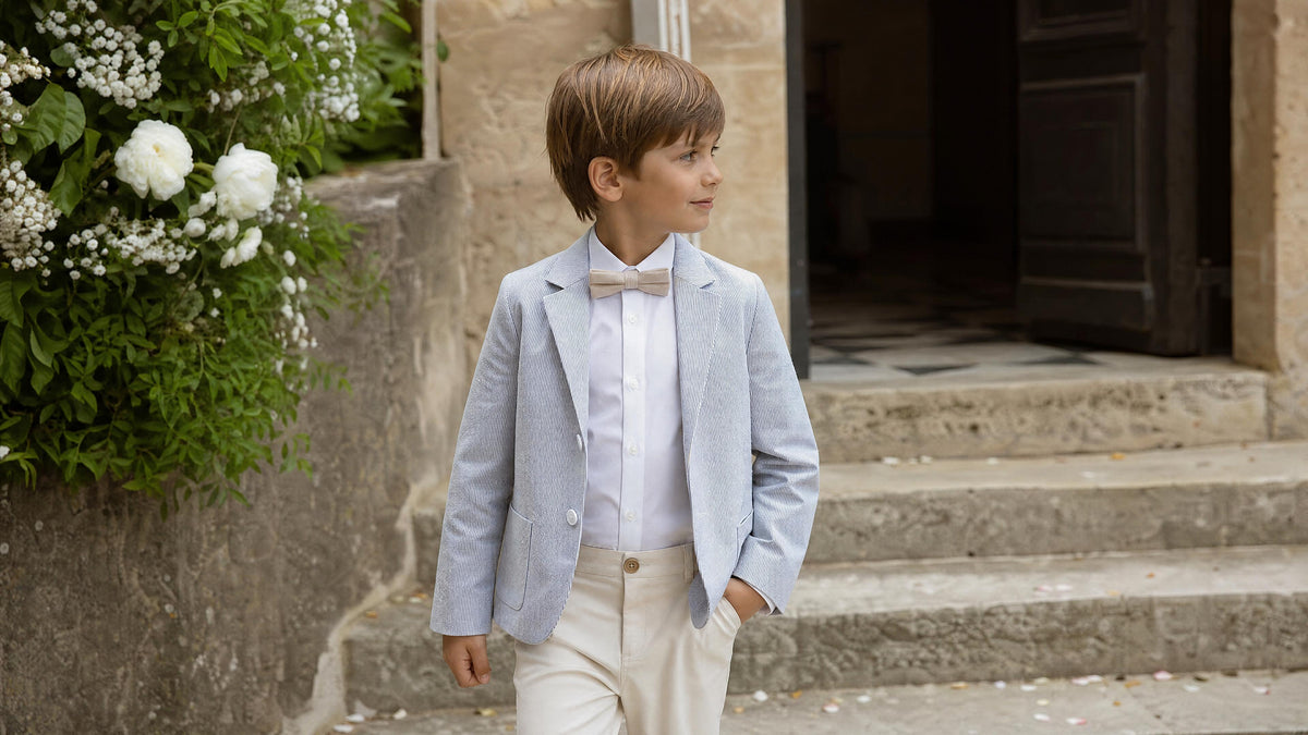 Garçon en tenue de cérémonie avec accessoires adaptés pour un mariage. Imagen
